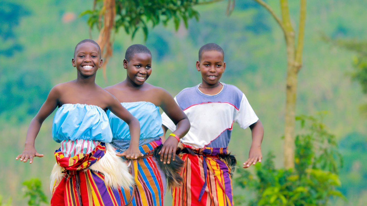 Three smiling dancers in colorful performance clothes
